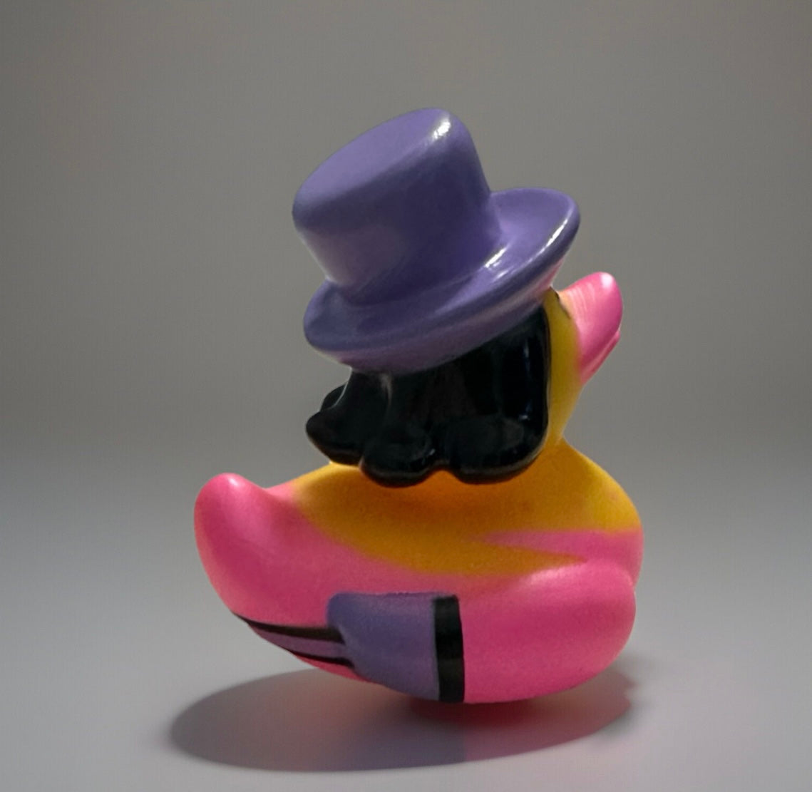 Purple top hat rubber duck with black hair and pink body from Reed’s Rubber Ducks and Sensory Shop