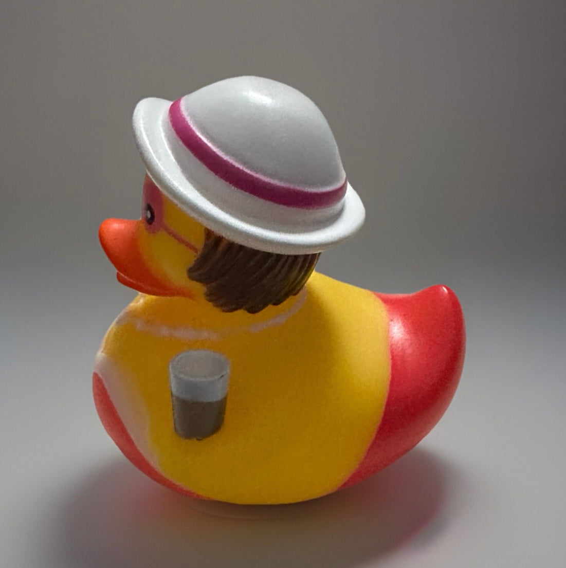 Red bouquet rubber duck gift wearing white hat with pink stripe and holding a gray cup