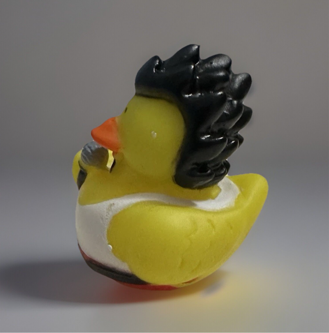 Rock and roll rubber duck toy with black spiked hair and microphone from Reed’s Rubber Ducks and Sensory Shop