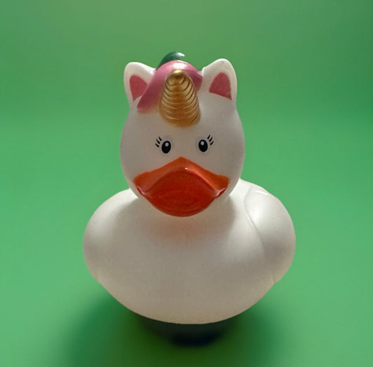 White unicorn rubber duck with golden horn and pink mane on green background unicorn rubber duck gift