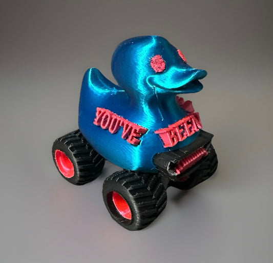 Blue duck toy on black and pink jeep wheels with pink text reading You've been ducked jeep