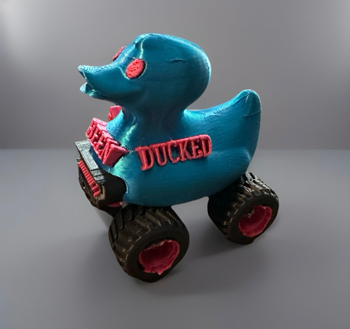 Blue rubber duck on large off-road wheels with red accents featuring You've been ducked jeep text